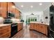 Open kitchen with stainless appliances, wood floors, granite countertops, and view to living space at 4882 Rabbit Farm Road Rd, Loganville, GA 30052