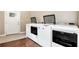 Laundry room with washer and dryer; featuring wooden floor and white walls at 4882 Rabbit Farm Road Rd, Loganville, GA 30052