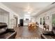 Spacious living room with wood floors, bright windows, ceiling fan, and view into the kitchen at 4882 Rabbit Farm Road Rd, Loganville, GA 30052