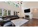 Cozy living room with a fireplace, TV and a large leather sectional sofa under a ceiling fan at 4882 Rabbit Farm Road Rd, Loganville, GA 30052