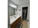 Bathroom with wood cabinets, neutral tile flooring, and shower with stylish curtains at 6432 Polar Fox Ct, Riverdale, GA 30296