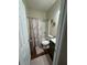 Neutral toned bathroom with shower-tub combo and dark wood vanity at 6432 Polar Fox Ct, Riverdale, GA 30296