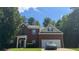 Charming two-story brick home featuring a two-car garage, manicured lawn, and classic architectural details at 6432 Polar Fox Ct, Riverdale, GA 30296