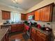 Kitchen with wooden cabinets, stainless steel appliances, dark countertops and a sink underneath a window at 6432 Polar Fox Ct, Riverdale, GA 30296
