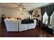 Bright living room with a ceiling fan, gray drapes, and dark hardwood floors, creating a cozy atmosphere at 6432 Polar Fox Ct, Riverdale, GA 30296