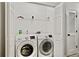 Convenient laundry room featuring modern washer and dryer, plus overhead shelving for storage at 1384 Dolcetto Nw Trce, Kennesaw, GA 30152