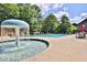 Fun community pool with a splash fountain, seating, and lush green surroundings at 1384 Dolcetto Nw Trce, Kennesaw, GA 30152
