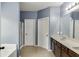 A bathroom with dual sinks, granite counters, tile floors, and walk-in shower at 1548 Station Ridge Dr, Lawrenceville, GA 30045