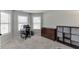 Well-lit room with neutral carpeting, multiple windows, a work desk, and storage dresser at 1548 Station Ridge Dr, Lawrenceville, GA 30045