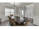 Formal dining room with dark wood table, six upholstered chairs, chandelier and wainscoting at 1548 Station Ridge Dr, Lawrenceville, GA 30045