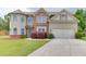 Charming two-story home featuring a manicured lawn, brick accents, and an attached two-car garage at 1548 Station Ridge Dr, Lawrenceville, GA 30045