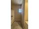 Bathroom featuring a white tiled tub and gray tile flooring with a window at 2103 River Rd, Ellenwood, GA 30294