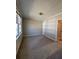 Neutral bedroom with plush carpeting, large window, and convenient access to a door, offering comfort and functionality at 2103 River Rd, Ellenwood, GA 30294