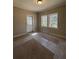 Cozy bedroom featuring neutral carpet, walls, two windows, and door at 2103 River Rd, Ellenwood, GA 30294