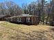 View of a brick house with black shutters surrounded by a lawn at 2103 River Rd, Ellenwood, GA 30294