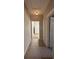 Hallway with neutral paint and flooring leading to the kitchen with a white refrigerator visible at 2103 River Rd, Ellenwood, GA 30294