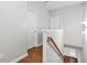 Hallway with brown wood floors, a wooden handrail, and white doors at 772 Aerial Se Way, Atlanta, GA 30312