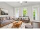 Bright living room featuring a gray sofa, armchairs, area rug, and large windows for natural light at 772 Aerial Se Way, Atlanta, GA 30312