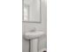 Modern powder room featuring pedestal sink, framed mirror and a clean, minimalist design at 772 Aerial Se Way, Atlanta, GA 30312