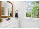Bathroom with a stylish mirror, sleek vanity, and a bright window view at 908 Lance Cir, Lawrenceville, GA 30043