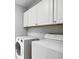 Laundry room with front loading washer, dryer, and storage space above at 908 Lance Cir, Lawrenceville, GA 30043