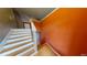 Staircase with white risers and a vibrant orange wall at 95 Willow Tree Ter, Covington, GA 30016