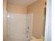 A clean bathroom featuring a shower-tub combo with white tile surround and neutral walls at 10103 Waldrop Pl, Decatur, GA 30034