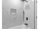 Modern bathroom featuring a tub with white marble tile, black trim, and shower fixture at 4000 Brittan Glade Trl, Snellville, GA 30039