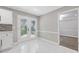 Bright kitchen features white cabinetry, double doors leading to yard, and stylish marble flooring at 4000 Brittan Glade Trl, Snellville, GA 30039