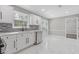 Bright kitchen includes white cabinets, mosaic backsplash, and door to the yard at 4000 Brittan Glade Trl, Snellville, GA 30039