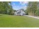 View of the home's rear featuring a well-kept lawn and two-car garage, ideal for outdoor living at 4000 Brittan Glade Trl, Snellville, GA 30039