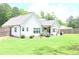 Expansive backyard view featuring a covered porch, lush lawn, and partial fence at 688 Harmony Rd, Temple, GA 30179