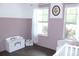 Bedroom features hardwood floors, natural light, a decorative toy box, and a glider chair with a pillow at 688 Harmony Rd, Temple, GA 30179