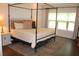 Bedroom featuring a canopy bed, side table, lamp, rug, and window at 688 Harmony Rd, Temple, GA 30179