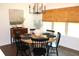 Well-lit dining area with a round wooden table and black chairs at 688 Harmony Rd, Temple, GA 30179