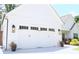 Close-up of a white two-car garage with decorative lights and landscaping at 688 Harmony Rd, Temple, GA 30179
