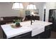 Modern kitchen island with a white countertop, black cabinets, and farmhouse sink at 688 Harmony Rd, Temple, GA 30179