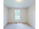 Neutral bedroom featuring a large window and plush carpet at 125 Ashbury Ct, Dallas, GA 30157