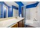 Blue bathroom has a shower-tub combo and a wide vanity with a large mirror at 1919 Cheatham Woods Sw Dr, Marietta, GA 30008