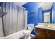 Bright blue bathroom features a shower-tub combo and single sink vanity at 1919 Cheatham Woods Sw Dr, Marietta, GA 30008