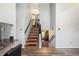 Bright entryway featuring wood-look floors, staircase with red accents, and views into the living spaces at 1919 Cheatham Woods Sw Dr, Marietta, GA 30008