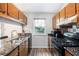 Functional kitchen with granite countertops, wood cabinets, stainless steel sink, and view of the backyard at 1919 Cheatham Woods Sw Dr, Marietta, GA 30008