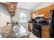Kitchen featuring wood cabinets, granite countertops, and black appliances at 1919 Cheatham Woods Sw Dr, Marietta, GA 30008
