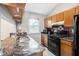 Functional kitchen with granite countertops, wood cabinets, and black appliances at 1919 Cheatham Woods Sw Dr, Marietta, GA 30008