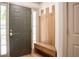 Welcoming foyer with modern storage bench, coat hooks, and natural light streaming through sidelight window at 3050 Baymount Dr, Lawrenceville, GA 30043