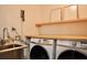 Laundry room with stainless steel sink, two washers, and a dryer at 3050 Baymount Dr, Lawrenceville, GA 30043