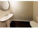 Powder room featuring pedestal sink, round mirror, and toilet at 3375 Highbury Way, Lithonia, GA 30038
