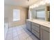 Spacious bathroom featuring a double sink vanity with large mirror, neutral tile floor and shower over a garden tub at 3375 Highbury Way, Lithonia, GA 30038