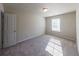 Neutral bedroom with plush carpet, large window, and a door that leads to the rest of the home at 3375 Highbury Way, Lithonia, GA 30038