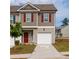 Charming two-story townhome with red shutters, a one-car garage and a well maintained lawn at 3375 Highbury Way, Lithonia, GA 30038